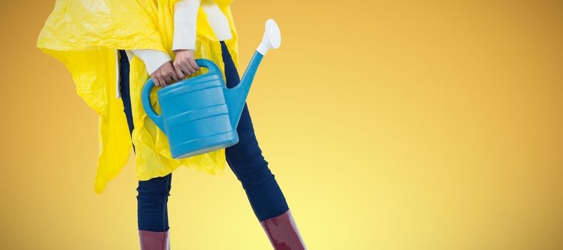 Woman in yellow raincoat holding an watering can against abstract yellow background