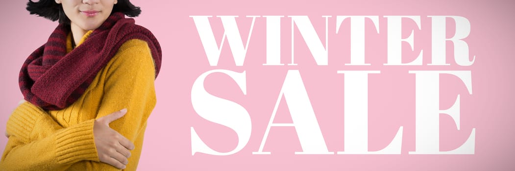 Woman in winter clothing posing against white background against pink background