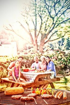 Close-up of barbecue and family sitting on the table in the park