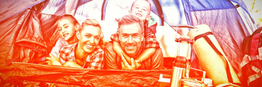 Portrait of smiling family lying in the tent