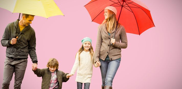  Smiling young family under umbrella against pink background