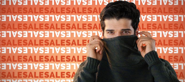 Portrait of man hiding face with sweater against abstract yellow background