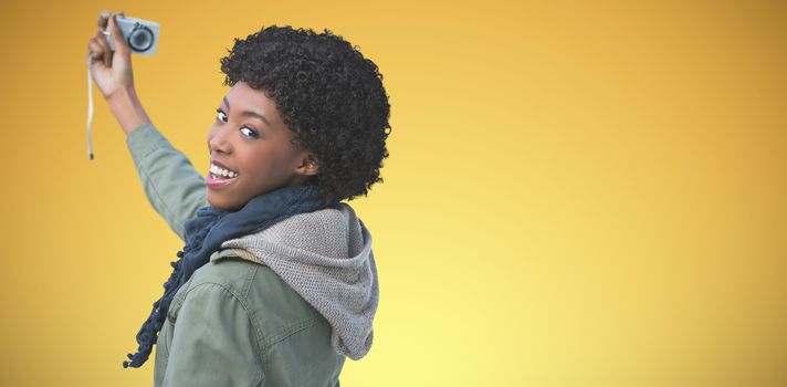 women taking selfies with camera against abstract yellow background