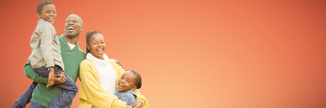 Portrait of a smiling young family laughing against abstract yellow background