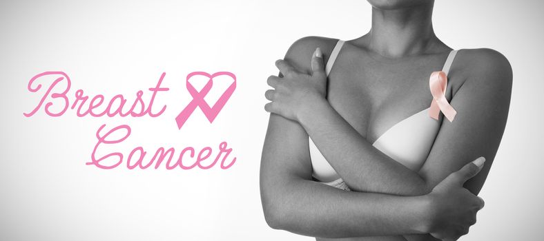 Breast cancer text with ribbon against woman for breast cancer awareness in bra
