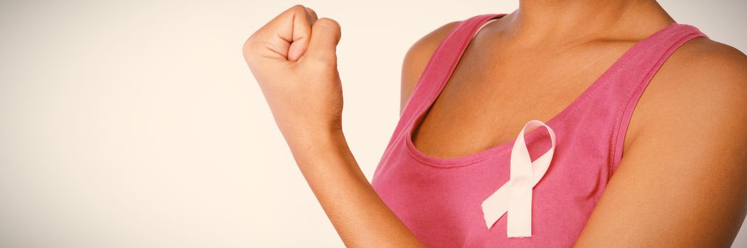 Woman shows pink ribbon for breast cancer awareness on white background