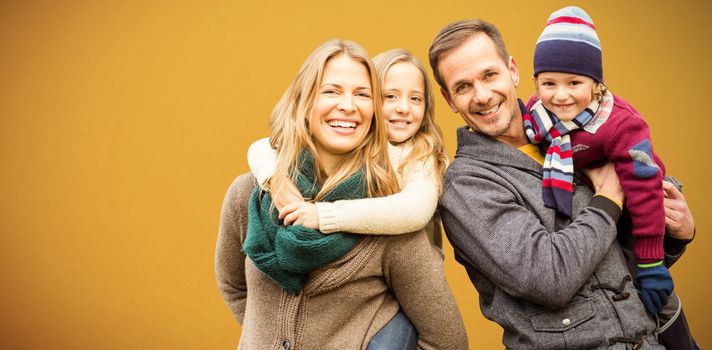 Portrait of family smiling together against orange background