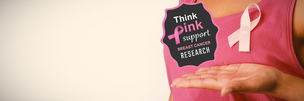 Breast cancer awareness message against woman showing pink ribbon for breast cancer awareness
