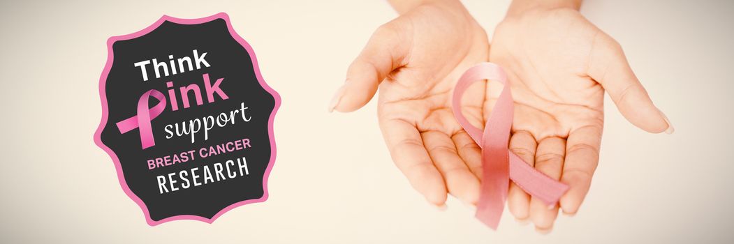 Breast cancer awareness message against two hands displaying pink ribbon for breast cancer awareness