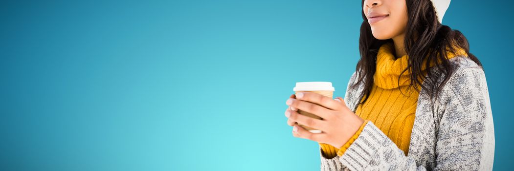 woman in warm clothing having coffee against abstract blue background