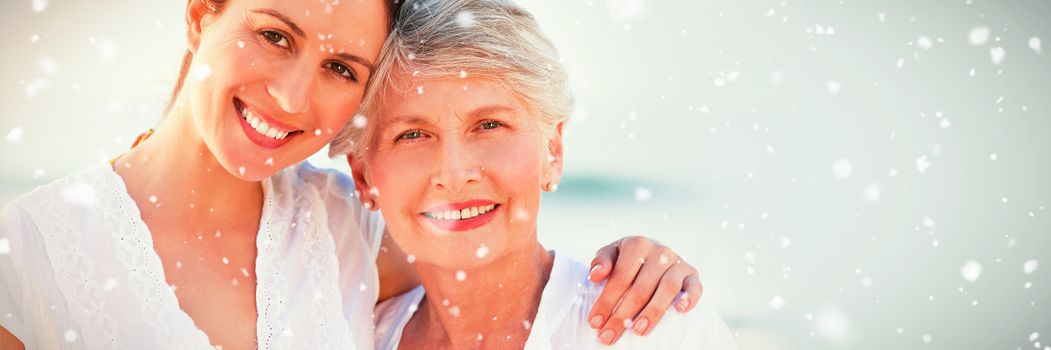 Snow falling against smiling daughter with her mother