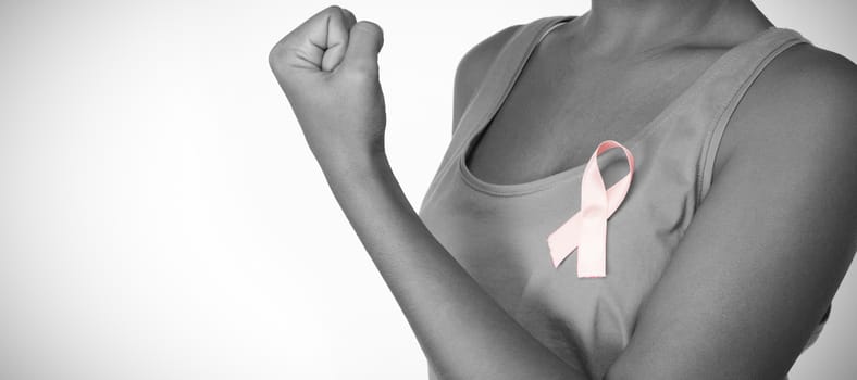 Woman shows pink ribbon for breast cancer awareness on white background