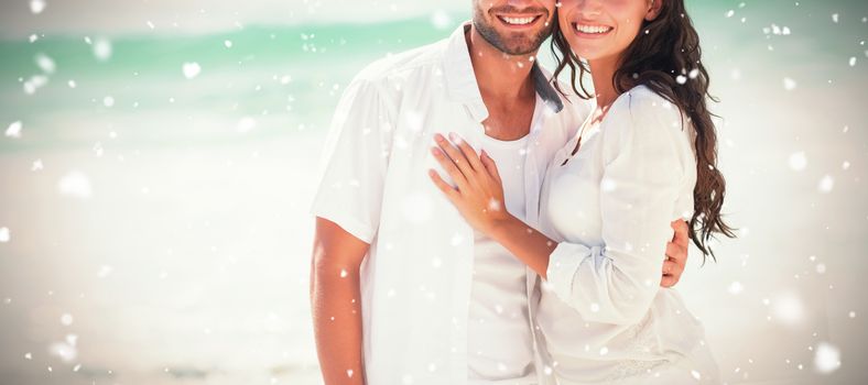 happy couple looking at camera  against snow falling