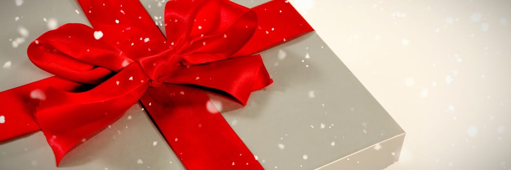 Snow falling against christmas gift in silver box