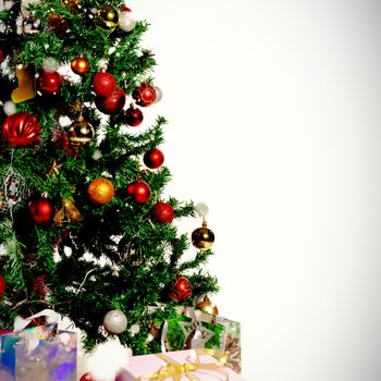 Snow falling against christmas pine tree with gifts