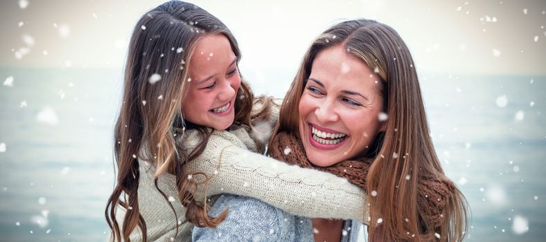 Snow falling against cheerful mother carrying daughter