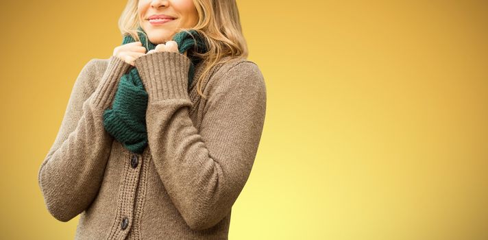  Smiling pretty woman holding her scarf against abstract yellow background