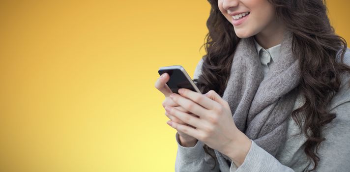 women using smartphone against abstract yellow background