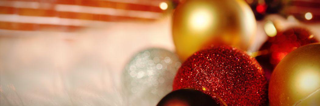 Colored Christmas ornaments on carpet against fake snow against christmas tree