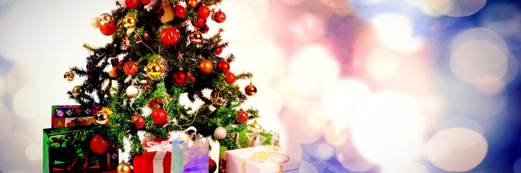 Defocused lights against snowcapped mountain against gifts under the christmas pine tree