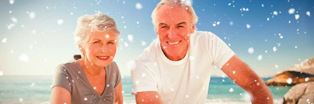 Snow falling against portrait of couple with their bikes