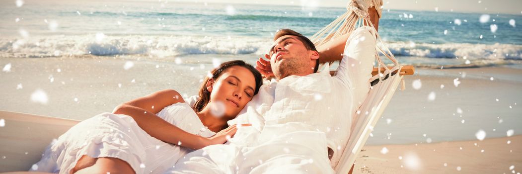 Calm couple napping in a hammock against snow falling