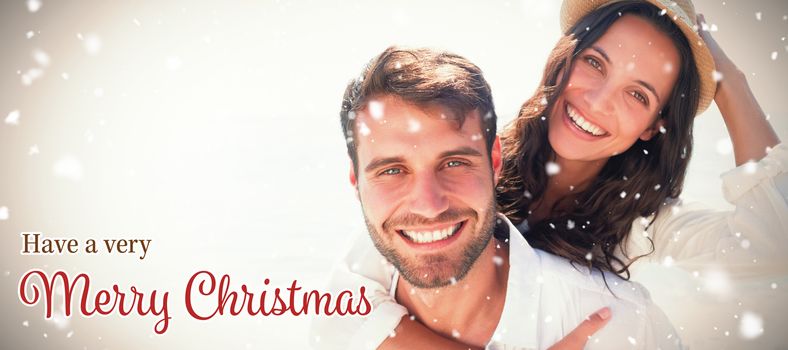 Man doing piggy-back to girlfriend  against christmas card