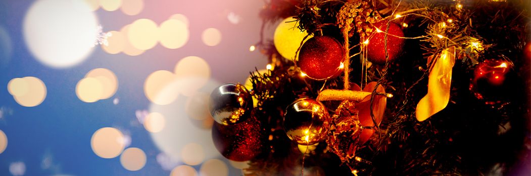 Defocused lights against snowcapped mountain against christmas garlands on a pine