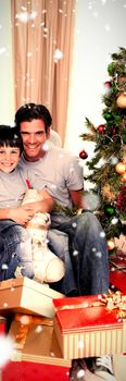 Happy family with lots of Christmas presents against snow falling