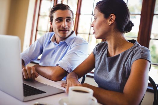 Young business people talking with each other in restaurant