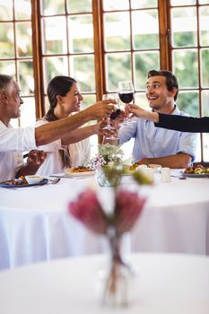 Happy business people toasting wine glasses in restaurant