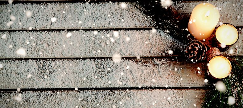 Snow falling against copy space in the snow with candles