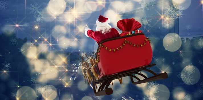 Santa Claus riding on sled with gift box against cars moving on road in city at night