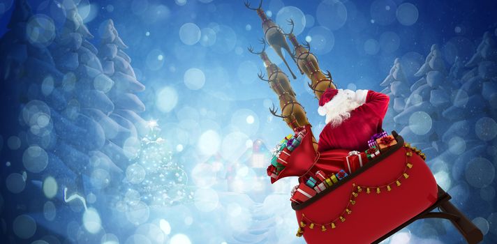 Rear view of Santa Claus riding on sled against winter village