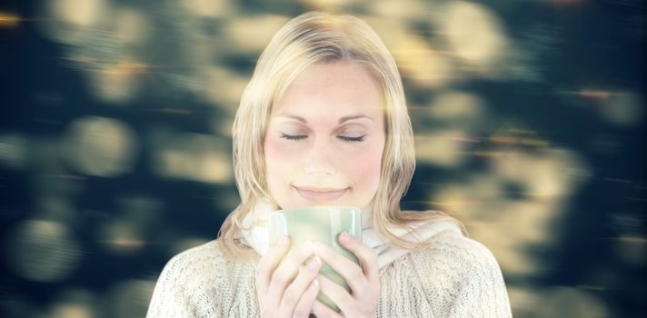 Happy woman enjoying a hot coffee standing  against shimmering light design on black