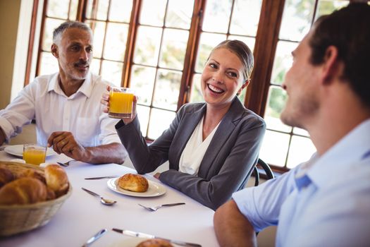 Smiling business people talking with each other in restaurant