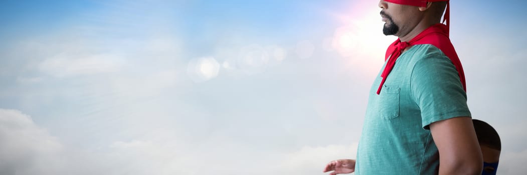 Man pretending to be a superhero against blue sky with white clouds