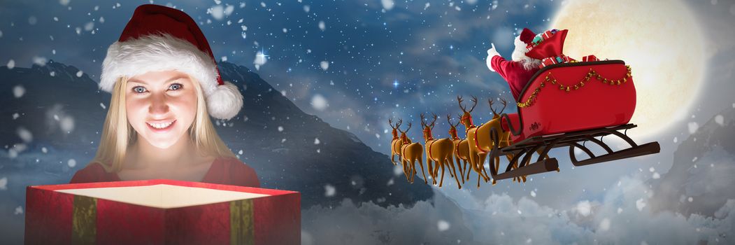 Festive blonde holding a gift against tent in countryside at night