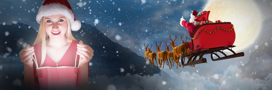 Festive blonde opening a gift bag against tent in countryside at night