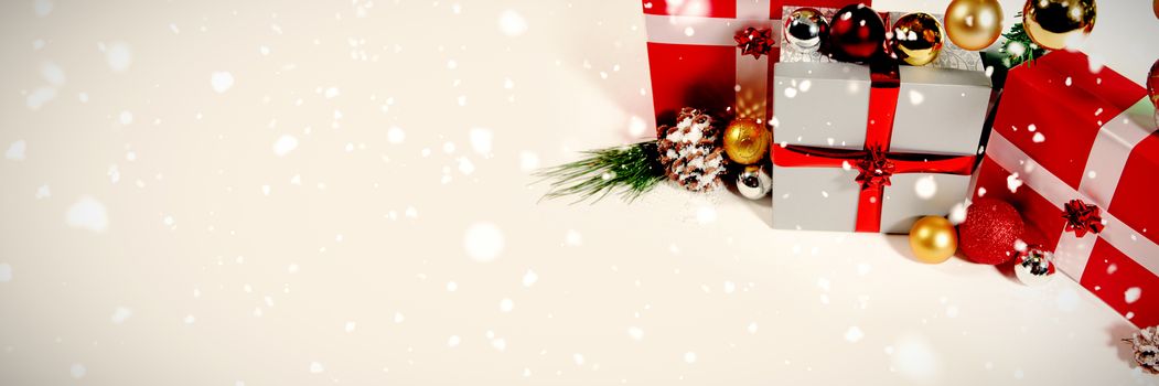 Snow falling against christmas gifts with white copy space