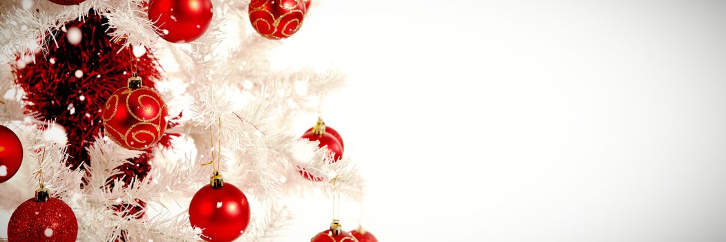 Snow falling against red and white christmas decorations