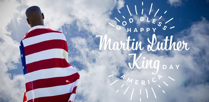 Rear view of man wearing american flag against bright blue sky with clouds