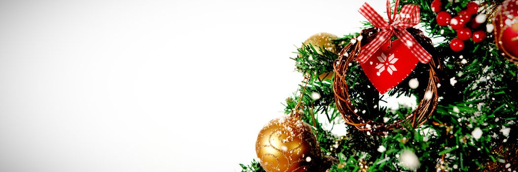 Snow falling against part of christmas tree against white background