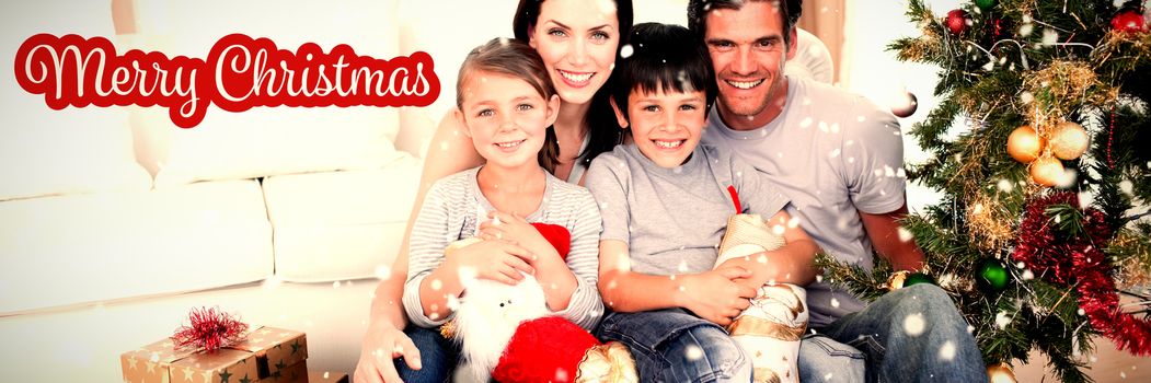 Happy family at Christmas time holding lots of presents against white and red greeting card