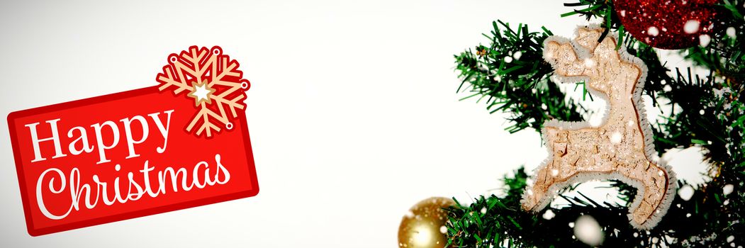 Greetings board against christmas ornaments hanging in tree with copy space