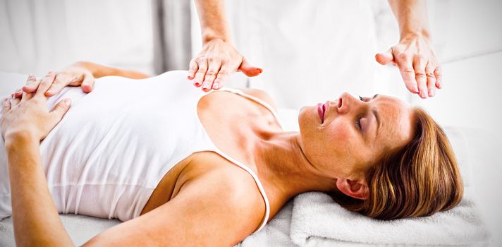 Woman receiving reiki treatment at spa
