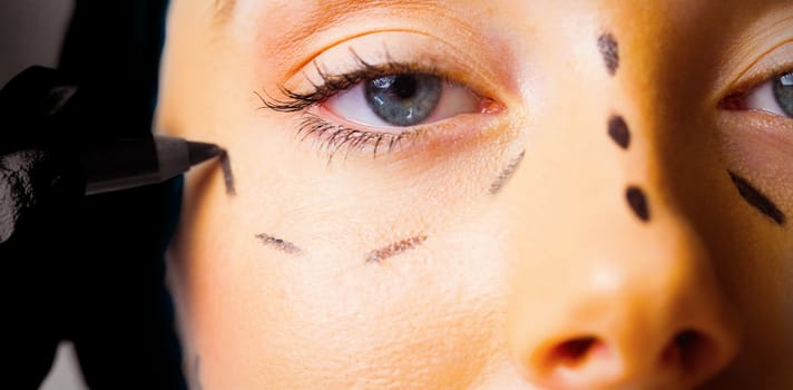 Peaceful young patient with dotted lines on the face in an examination room