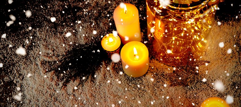 Snow falling against christmas smooth lights and candles