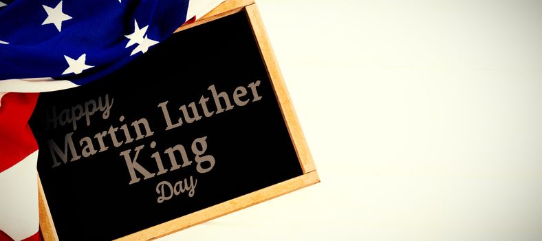 happy Martin Luther King day against american flag and slate on table