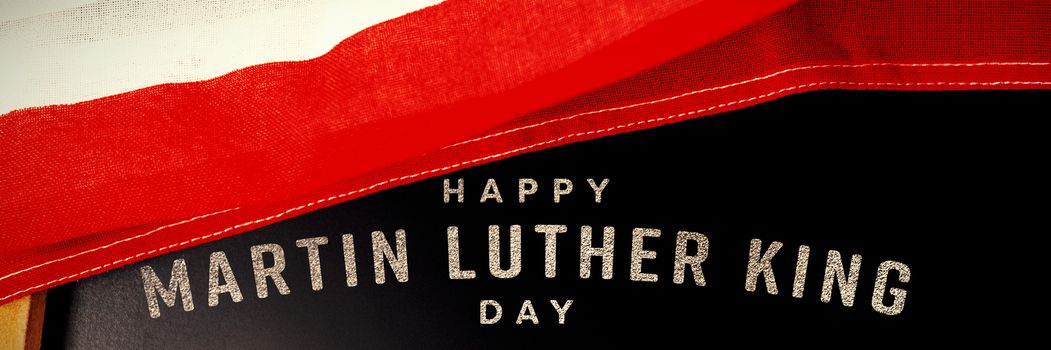 happy Martin Luther King day against american flag and empty slate on wooden table